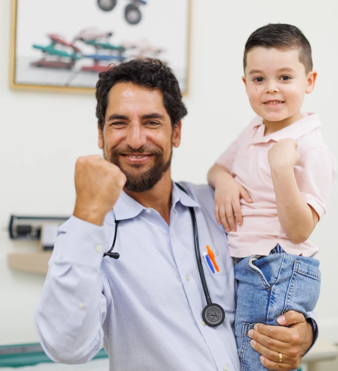 Dr. Hallenbeck and a young patient raising their fists in celebration